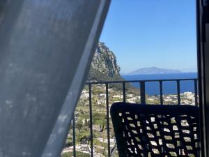 Ein Stuhl auf einem Balkon mit Blick auf das Meer in der Unterkunft Domus Capri in Capri