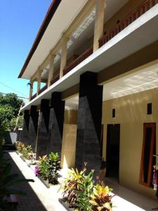 una vista lateral de un edificio con algunas plantas en Guest house KupuKupu39, en Kuta