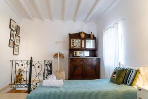 a bedroom with a bed and a wooden cabinet at Nina's Traditional House by Estia in Valaneíon