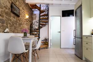 a kitchen and dining room with a stone wall at Nina's Traditional House by Estia in Valaneíon