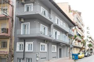 un bâtiment gris avec des balcons blancs dans une rue dans l'établissement MeYia studios, à Thessalonique