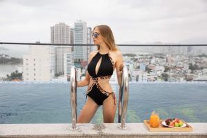 a woman in a bikini standing on the edge of a pool at Elite Hotel Nha Trang in Nha Trang