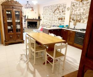 una cucina con tavolo e sedie in legno di Casa D'Aurora a Pettorano sul Gizio