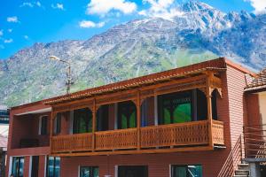 a building with a balcony with a mountain in the background at Fiten house in Kazbegi
