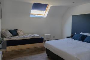 a bedroom with two beds and a window in it at Au Petit Canteleu - Bed & Breakfast in Beloeil