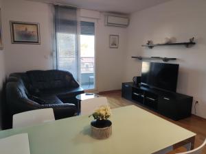 - un salon avec un canapé en cuir noir et une table dans l'établissement Apartment Josip Split, à Split