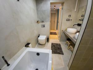 a bathroom with a tub and a toilet and a sink at Like Home 1 Perfect Classic Duo in Świdnica