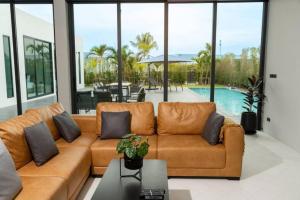 a living room with a couch and a pool at The Stay Huahin 2 in Khao Tao