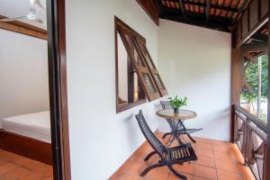 a balcony with a table and chairs and a bed at NeakBong Residence in Siem Reap