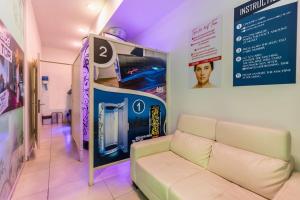 a living room with a couch and a sign at Studio room 11 with kitchenette in the heart of St Julians in Paceville