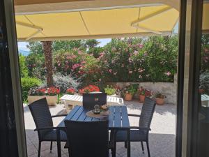 een patio met een tafel en stoelen en een parasol bij Apartments Dajana Silo in Šilo