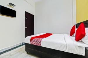 OYO Hotel Pallavi Residency في ميروت: غرفة نوم عليها سرير ومخدات حمراء