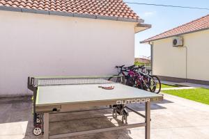 a ping pong table in front of a house at Holiday Home Endi in Lozovac