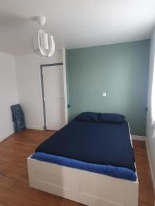 una camera da letto con un letto con una coperta blu di Appartement cosy a Lourdes