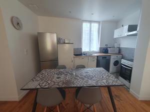 una cucina con tavolo e sedie in una cucina di Appartement cosy a Lourdes