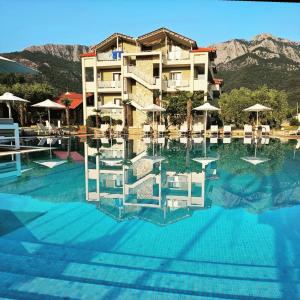 um hotel com uma piscina com montanhas ao fundo em Korina Hotel em Skala Potamias