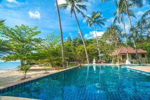 a swimming pool next to a beach with palm trees at Am Samui Resort Taling Ngam in Taling Ngam Beach