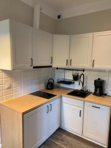 cocina con armarios blancos y encimera en Apartamenty Villa Akant, en Piechowice