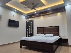 a bedroom with a large bed with a ceiling at Surya Niwesh 103 in Varanasi