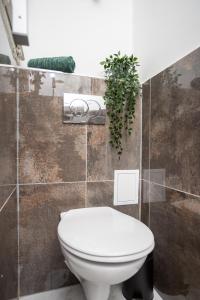 a bathroom with a toilet and a plant on the wall at Green Goblin Apartment with FREE PRIVATE PARKING in Budapest