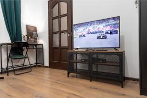 a living room with a flat screen tv on a stand at Green Goblin Apartment with FREE PRIVATE PARKING in Budapest