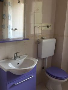 ein Badezimmer mit einem Waschbecken, einem WC und einem Spiegel in der Unterkunft Trilocale IMMinens mari in Copanello