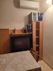 a room with a table and a microwave and a television at Ana apartman in Bar
