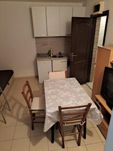 a kitchen with a table and two chairs and a kitchen with a stove at Ana apartman in Bar
