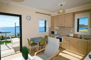 a kitchen with a table and chairs and a balcony at Captains View Apartments in Platy +10 photos