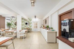 een restaurant met witte muren en tafels en een keuken bij Apartments Villa Nina in Fažana