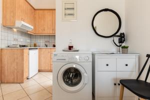 een keuken met een wasmachine en een spiegel bij Vaso studios & apartment in Naxos town in Naxos Chora