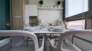 ein Esszimmer mit einem Tisch und Weingläsern in der Unterkunft GEMELOS sea front apartment in Benidorm