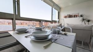 einen Tisch mit Tellern und Weingläsern darauf in der Unterkunft GEMELOS sea front apartment in Benidorm