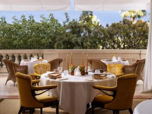 una sala da pranzo con tavoli e sedie su un patio di Hôtel Métropole Monte-Carlo - Deux restaurants étoilés a Monte Carlo