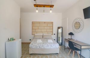 um quarto com uma cama e uma secretária e uma cama sidx sidx em VILLA ALFONSINA em Uggiano la Chiesa