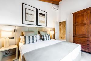 1 dormitorio con cama blanca y armario de madera en Cas Misser en Algaida