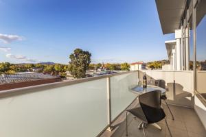 a balcony with a table and chairs on a building at Quest Albury in Albury