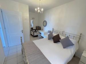 a bedroom with a large white bed with pillows at Bluview, Glyfada, Corfu in Glyfada