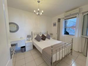 a bedroom with a bed and a desk and a window at Bluview, Glyfada, Corfu in Glyfada