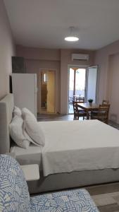 a bedroom with a large white bed and a table at Deluxe Summer Studio Tolo in Tolo