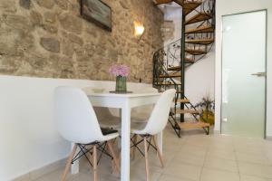 a dining room with a white table and white chairs at Nina's Traditional House by Estia in Valaneíon