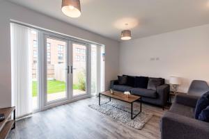 a living room with a couch and a table at Saxelbye House - Cosy 3 Bed Home near City Centre in Derby