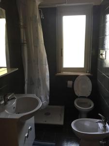 a bathroom with a sink and a toilet and a window at Bilo Copanello Imminens Mari in Copanello