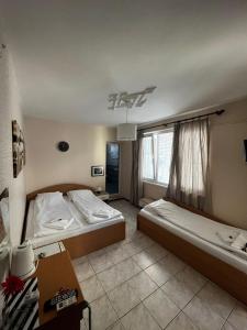 a bedroom with two beds and a window at Kъща за гости Христина in Lozenets