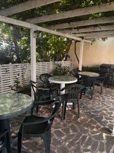 un grupo de mesas y sillas en un patio en Kъща за гости Христина, en Lozenets