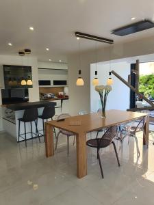 Villa Daniel Saint Aygulf في فريجوس: مطبخ وغرفة طعام مع طاولة وكراسي خشبية