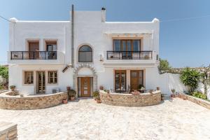 een groot wit huis met een stenen binnenplaats bij Vaso studios & apartment in Naxos town in Naxos Chora