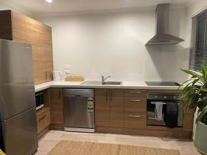een keuken met een roestvrijstalen koelkast en een wastafel bij An elegant 2-bedroom house in Hamilton central. in Hamilton