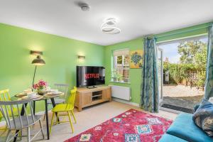 a living room with a tv and a table and chairs at #034 Saunders Rest in Norwich