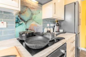 a kitchen with a stove with pots and pans on it at #034 Saunders Rest in Norwich